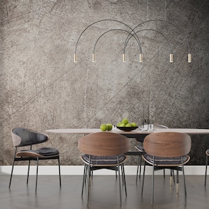 May include: A dining room set with a wooden table and six chairs. The chairs have black metal legs and brown wooden seats. The table has a light wood finish and a black metal base. The wall behind the table is a textured gray with a black metal light fixture hanging from the ceiling.