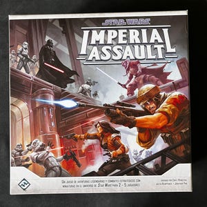 Puede incluir: Caja del juego de mesa Star Wars Imperial Assault. La ilustración muestra una escena de batalla con personajes como Darth Vader y Stormtroopers. El juego es para 2-5 jugadores y presenta miniaturas.