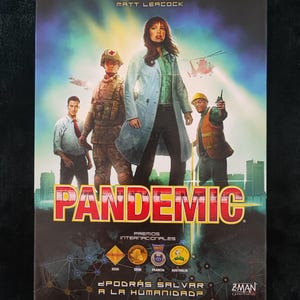 Op de afbeelding: Een bordspeldoos met de titel "Pandemic" met een dramatische illustratie. De afbeelding toont een groep mensen, waaronder een vrouw in een labjas en een militair figuur. De tekst bevat "Un Juego de Matt Leacock" en "¿Podrás Salvar a la Humanidad?"