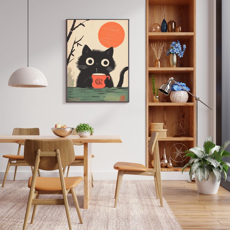 May include: A framed art print featuring a black cat holding a red mug with a graphic of a cat. The cat is set against a backdrop of a rising sun and a green surface. The art has a Japanese aesthetic.