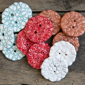 Peut inclure: Un ensemble de boutons en céramique avec des motifs complexes. Les boutons sont dans des tons de rouge, blanc, bleu et marron.