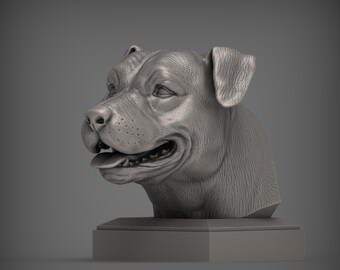 Puede incluir: Una escultura gris de la cabeza de un perro, que muestra texturas y detalles precisos. La boca del perro está ligeramente abierta, revelando su lengua y dientes. La escultura está montada sobre una base rectangular, sobre un fondo gris.