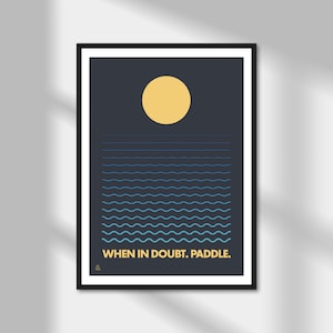 May include: A dark blue poster with a yellow sun and blue waves. The text "WHEN IN DOUBT, PADDLE." is at the bottom of the poster.