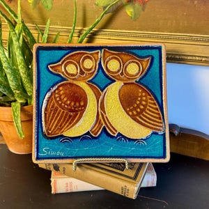 May include: A set of three ceramic mugs with a speckled, matte finish. Each mug features a different color: light blue, cream, and gray. The mugs have a simple, modern design with a rounded shape and a comfortable handle.