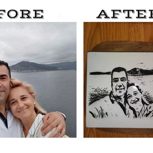 May include: A black and white photograph of a couple has been engraved onto a white ceramic tile. The tile is framed with a dark wood border and is sitting on a wooden surface.