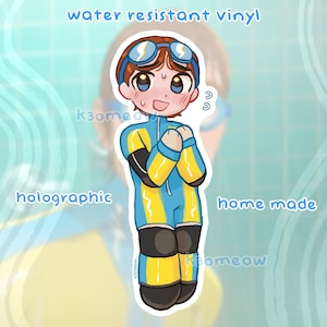 Könnte beinhalten: Ein wasserfester Vinyl-Aufkleber mit einer Cartoonfigur in einem blau-gelben Taucheranzug und einer Brille. Der Aufkleber trägt die Aufschrift "water resistant vinyl", "holographic" und "home made".