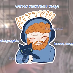 May include: A holographic, water-resistant vinyl sticker featuring a cartoon illustration of a person with orange hair and a beard, wearing a blue hoodie and holding a black cat. The word "KITTY!!!" is above the person.