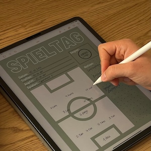 Könnte beinhalten: Eine grüne und weiße digitale Planervorlage für einen Spieltag. Die Vorlage enthält einen Bereich für Datum, Uhrzeit, Gegner, Ort und Notizen. Die Vorlage enthält auch ein Diagramm eines Fußballfeldes mit Nummern für die Spielerpositionen.