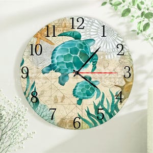 May include: A round wall clock featuring a vintage map background with two teal sea turtles, a starfish, and coral illustrations. The clock face displays black Arabic numerals from 1 to 12, with black hour and minute hands and a red second hand.