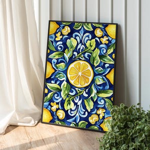 Puede incluir: Una impresión artística enmarcada con un diseño de acuarela de limones, hojas y elementos florales sobre un fondo azul oscuro. La obra de arte tiene una rodaja de limón central y un patrón repetitivo de amarillo y verde. El marco es negro.
