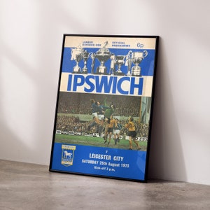 May include: A vintage football match programme for the Ipswich Town vs Leicester City game on 25th August 1973. The programme features a photo of the game in progress with the score 0-0. The programme is blue and white with the text "Ipswich" in large bold letters.