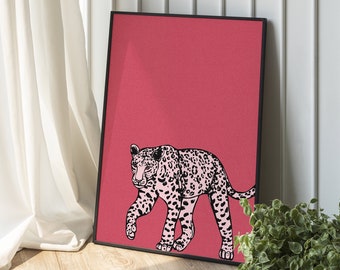 May include: A black framed print with a pink leopard walking on a red background.