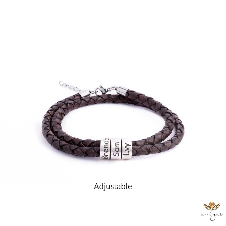 K&ouml;nnte beinhalten: Braunes Lederarmband mit verstellbarem Verschluss und silbernen Perlen, die mit den Namen Brenda, Sam und Ivy graviert sind.