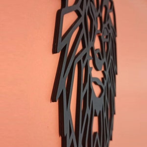 May include: A black wall art piece featuring a geometric, angular lion head design. The cutout structure is composed of sharp, intersecting lines that form the mane and facial features of the lion, presented in a flat, matte black finish.