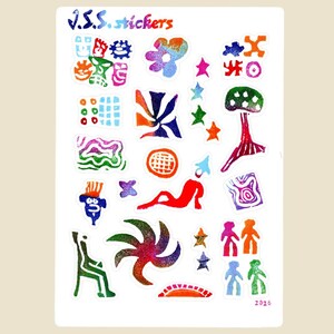 May include: A sheet of colorful stickers with various abstract designs. The stickers include shapes like stars, flowers, and figures, with the text "J.S.S. stickers" at the top. The stickers are in shades of blue, red, green, orange, and purple.