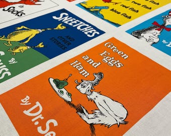 May include: A fabric panel featuring colorful squares with illustrations and text from Dr. Seuss books. The squares include titles like "Green Eggs and Ham," "Sneetches," and "Fox in Socks," with vibrant colors and whimsical characters.