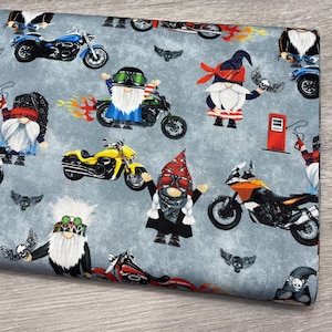 May include: Fabric with a repeating pattern of biker gnomes and motorcycles in various colors. The gnomes wear bandanas, sunglasses, and biker gear. Motorcycles are blue, yellow, orange, and green. The background is a mottled gray.