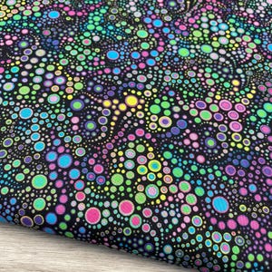 May include: Black fabric with a vibrant pattern of colorful, overlapping circles in shades of pink, green, blue, yellow, and purple. The circles vary in size and density, creating a dynamic and visually engaging design. The fabric has a slight sheen.