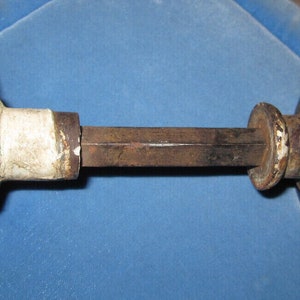 May include: A vintage door knob with a brown and gold marbled finish. The knob is attached to a metal rod.