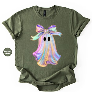 Op de afbeelding: Olijfgroen T-shirt met een kleurrijk spookontwerp en een grote strik. Het spook heeft zwarte ovale ogen en een iriserend lichaam in paars, blauw en geel. Het shirt is een casual stijl met korte mouwen.