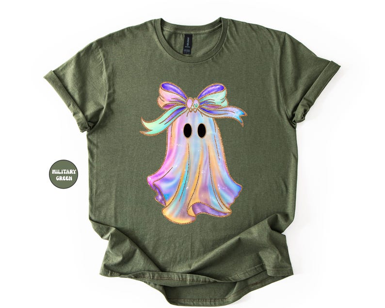 Op de afbeelding: Olijfgroen T-shirt met een kleurrijk spookontwerp en een grote strik. Het spook heeft zwarte ovale ogen en een iriserend lichaam in paars, blauw en geel. Het shirt is een casual stijl met korte mouwen.