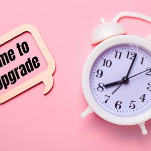 May include: A white alarm clock with black hands and a pink background. The clock face reads "Time to Upgrade".