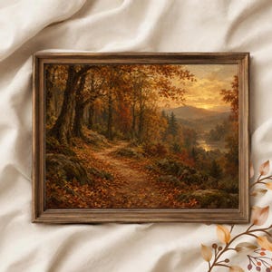 Puede incluir: Un cuadro de paisaje rectangular enmarcado que representa una escena de bosque otoñal con un sendero sinuoso cubierto de hojas caídas, árboles grandes, terreno rocoso y un río lejano bajo un cielo dorado al atardecer.