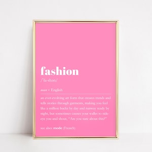 May include: A pink printable wall art print with a gold frame. The print features the word "fashion" in white bold letters with a definition below. The definition reads: "an ever-evolving art form that creates trends and tells stories through garments, making you feel like a million bucks by day and runway ready by night, but sometimes causes your wallet to side-eye you and shout, "Are you sure about this?" see also mode (French)"