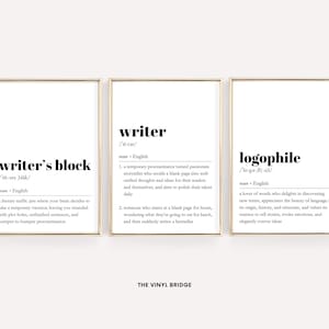 May include: Three black and white printable wall art prints with gold frames. The prints feature the definitions of "writer's block", "writer", and "logophile".