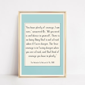 May include: A light blue printable quote poster with a white border and gold frame. The quote is from "The Wonderful Wizard of Oz" by L. Frank Baum, published in 1900. The quote reads: "You have plenty of courage, I am sure, answered Oz. "All you need is confidence in yourself. There is no living thing that is not afraid when it faces danger. The true courage is in facing danger when you are afraid, and that kind of courage you have in plenty."