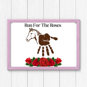 May include: A pink framed print with the text "Run For The Roses" and a brown horse silhouette with a handprint design. Red roses are at the bottom of the print.