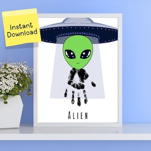Pode incluir: Uma impressão emoldurada com um alienígena verde com um corpo de impressão de mão em preto e branco, sob um OVNI cinza. A palavra "ALIEN" está impressa abaixo. Um post-it amarelo com "Download instantâneo" está no canto superior esquerdo.