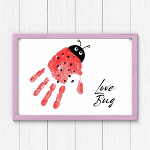 Op de afbeelding: Een roze ingelijste print met een rode lieveheersbeestje handafdruk en de tekst "Love Bug".