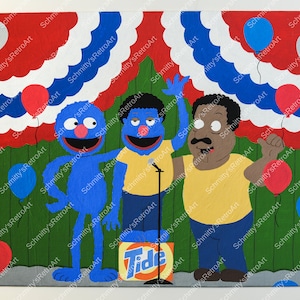 May include: Three blue Sesame Street characters stand on a stage decorated with red, white, and blue bunting and balloons. The character on the right is holding a microphone. The character in the middle is holding a sign that says "Tide".