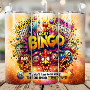 May include: A set of three insulated tumblers with a vibrant bingo-themed design. Each tumbler features the words "LUCKY BINGO" with colorful graphics of bingo balls, cards, and a cartoon chicken. The text "You don't have to be crazy TO BE OUR FRIEND, WELL TRAN YOU!" is also included.