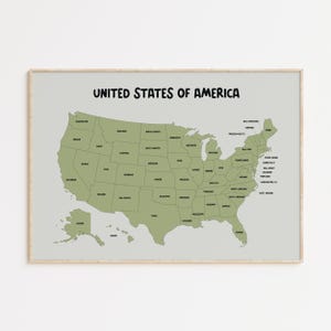 Peut inclure: Une carte encadrée des États-Unis d'Amérique. La carte est de couleur vert clair, chaque État étant délimité et étiqueté. Le titre "UNITED STATES OF AMERICA" est écrit en lettres noires et grasses en haut de la carte.