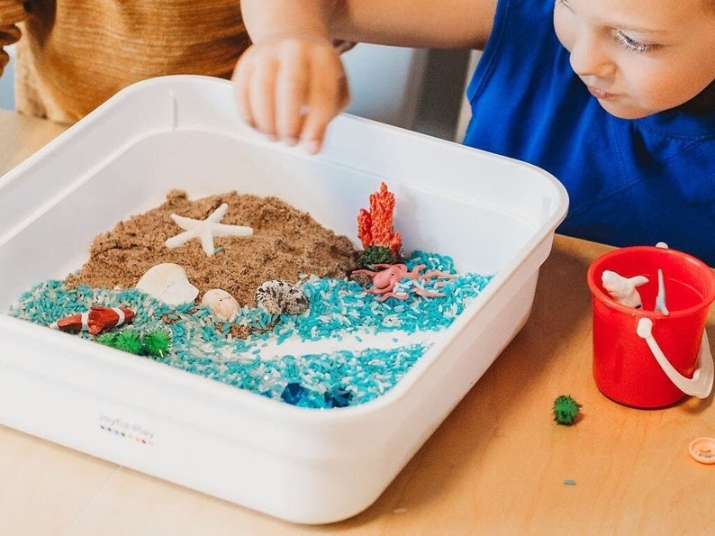 Kids setting up their sensory play kit with all the different items included.