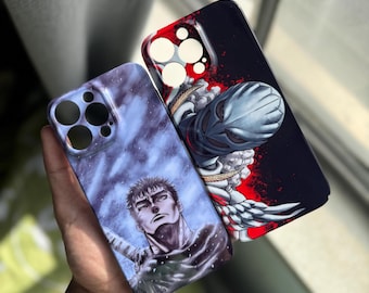 以下が含まれることがあります： 異なるデザインの携帯電話ケース2つ。1つのケースは剣を持ったキャラクターの白黒イラスト、もう1つのケースはヘルメットと翼を持ったキャラクターの黒と赤のイラストです。