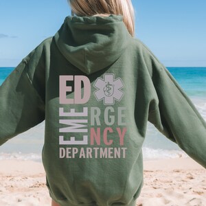May include: Green hooded sweatshirt with the text "ED EMERGENCY DEPARTMENT" in pink and white letters with a star of life symbol in grey.