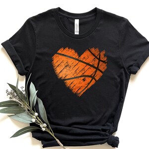 May include: Black t-shirt with a distressed orange basketball shaped heart graphic.