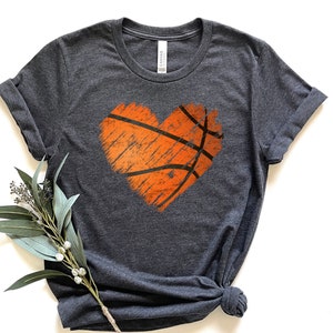 May include: A dark heather grey t-shirt featuring a distressed orange basketball graphic in the shape of a heart.