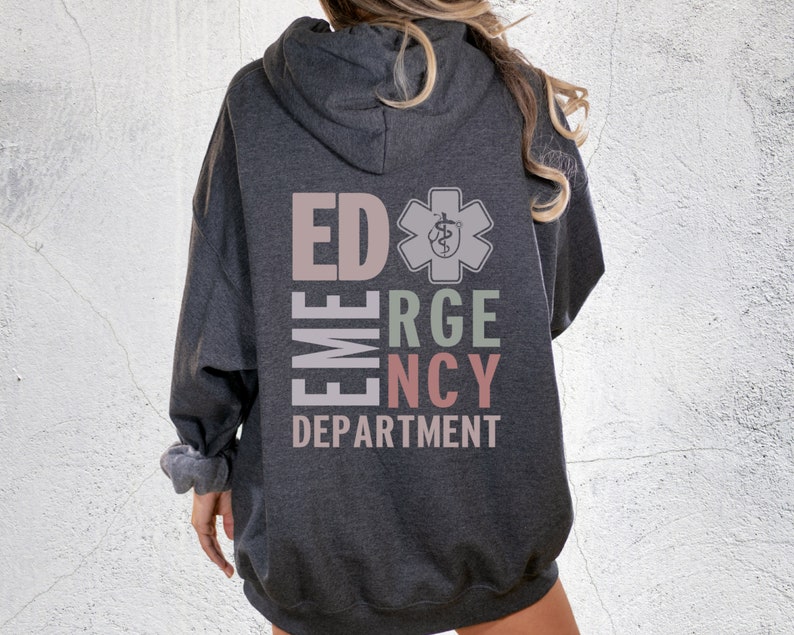 May include: A dark grey hooded sweatshirt with the text "ED EMERGENCY DEPARTMENT" in a vertical column with a medical symbol in the center. The text is in different colors, including pink, green, and light brown.