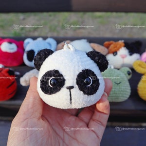 May include: A collection of handmade crocheted animal plushies, including a panda, tiger, frog, cat, and cow. The plushies are all small and have cute faces.