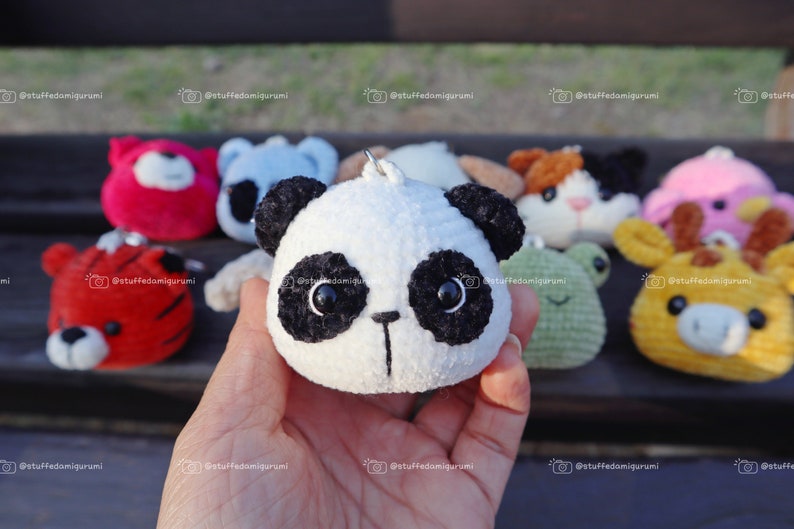May include: A collection of handmade crocheted animal plushies, including a panda, tiger, frog, cat, and cow. The plushies are all small and have cute faces.