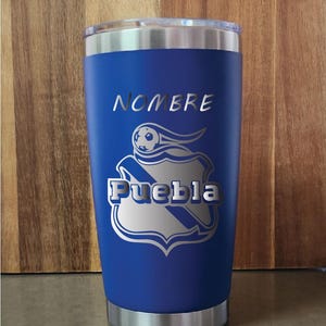 May include: A blue stainless steel tumbler with a silver logo of a soccer ball and the words "NOMBRE" and "Puebla".