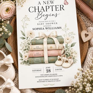 May include: A white baby shower invitation card featuring a stack of four books tied with a cream ribbon, surrounded by white flowers and a small butterfly. The text reads A NEW CHAPTER BEGINS, BABY SHOWER, SOPHIA WILLIAMS, JUNE 28, 2:00 PM.