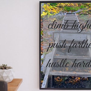 May include: A motivational quote on a wooden sign with a rustic background. The quote reads "climb higher push farther hustle harder".