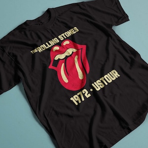 May include: Black t-shirt with a vintage-style graphic of The Rolling Stones tongue logo and the text "1972 - USTOUR".