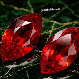May include: Two marquise-cut, faceted red gemstones with brilliant internal reflections. The gems are displayed against a dark green background with gold accents. The text "gemsbuildaslam" is visible in the upper right corner.