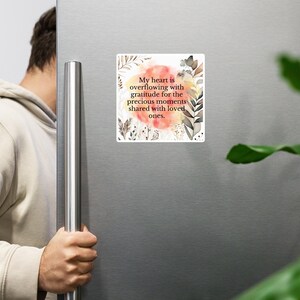 May include: A square magnet with a watercolor design and the text "My heart is overflowing with gratitude for the precious moments shared with loved ones." The design features a soft pink and orange center with floral and leaf accents.